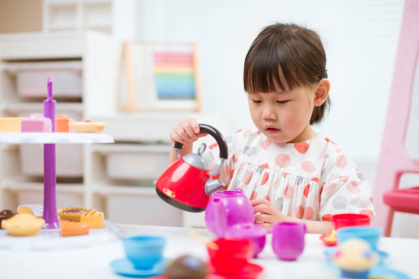 niña niña fingir juego preparando la fiesta de té en casa - tea party little girls teapot child fotografías e imágenes de stock