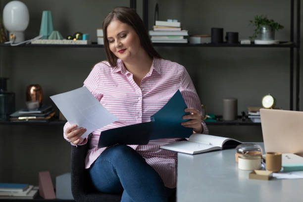istock Successful Plus Size Businesswoman Reading Documents at the Office 1224701678
