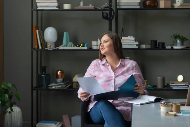 istock Successful Plus Size Businesswoman Reading Documents at the Office 1224701680