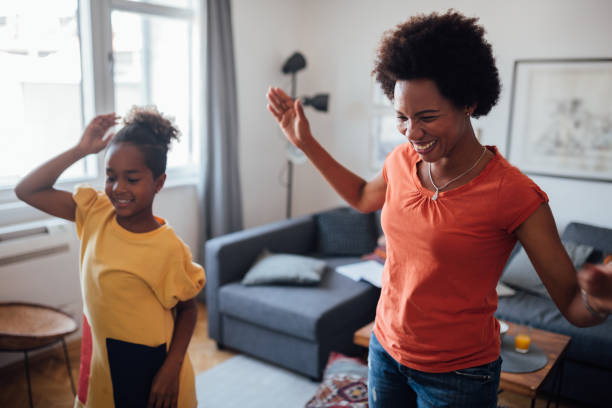 istock Mother and daughter dancing at home 1224702187