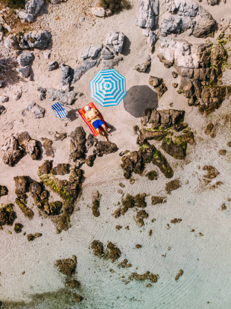 istock Aerial View Man Sunbathing on the Untouched Beach 1224702919