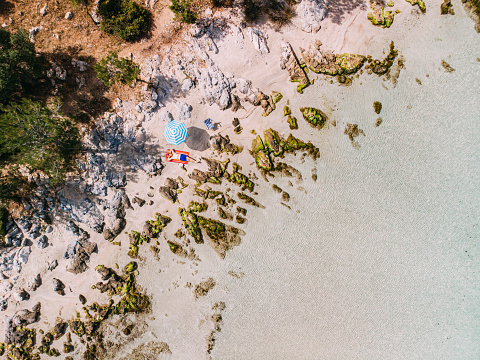 Aerial View Man Sunbathing on the Untouched Beach