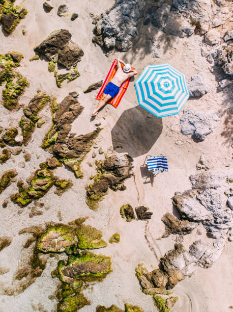 Aerial View Man Sunbathing on the Untouched Beach
