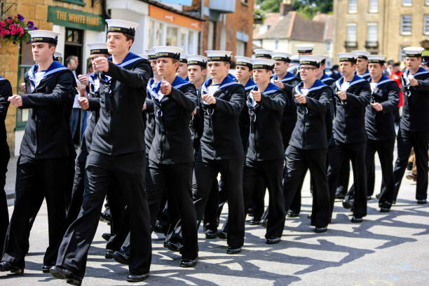 uk armed forces day parade royal navy sailors from hms heron marching through sherborne dorset, uk - saluting sailor armed forces men foto e immagini stock