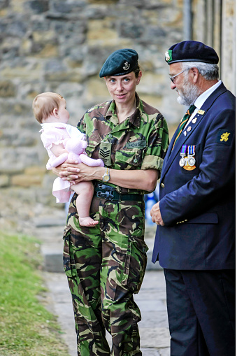 Female British Army Sargeant with her young baby daughter at the National Armed Forces Day Parade in Sherborne Dorset, UK