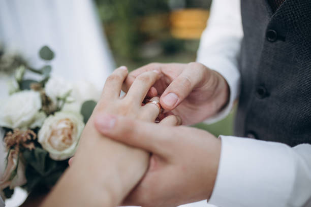 istock a man wearing a wedding ring on his wife's finger 1224705051