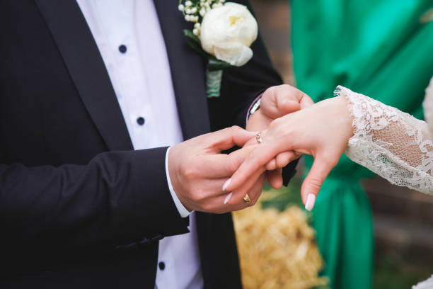 istock a man wearing a wedding ring on his wife's finger 1224705327