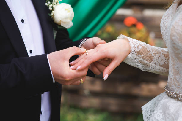 istock a man wearing a wedding ring on his wife's finger 1224705410