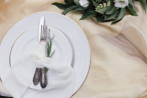 istock Knife, white plate and fork on beige background. 1224706293