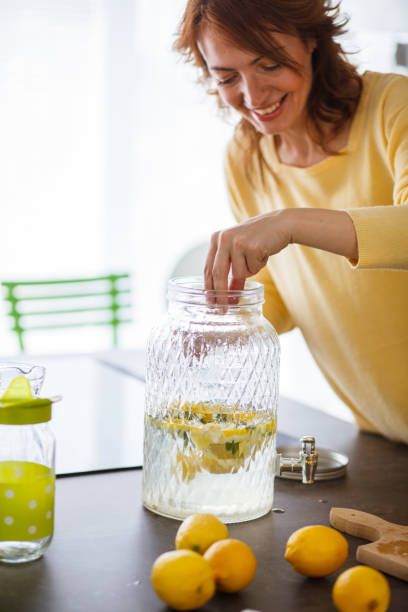 istock Side view of a smiley woman making lemonade juice 1224712944