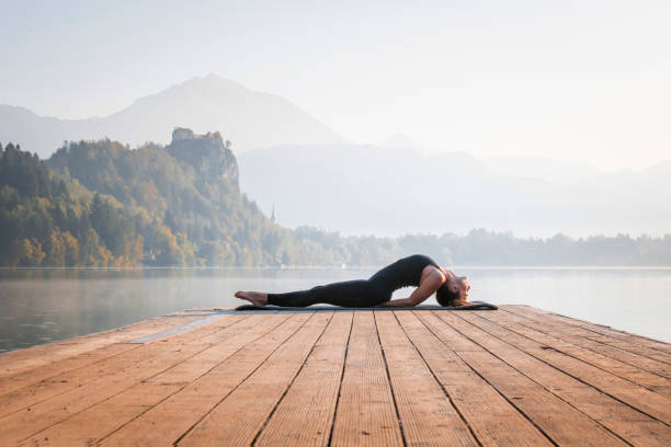 istock Woman in Yoga Fish Posture on Pier Overlooking Lake Bled 1224713521