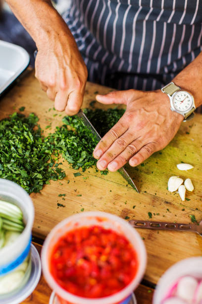 istock A man's hands cutting cilantro on a wooden cutting board 1224716283