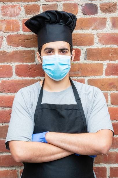 istock Young chef posing with a protective mask and gloves during a break looking at the camera 1224720102