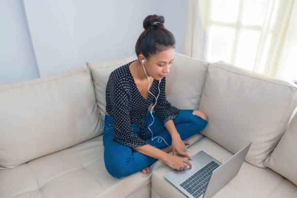 istock professional entrepreneur working at home through a laptop, a young woman using a laptop device while sitting on the couch, concept of work process 1224720392