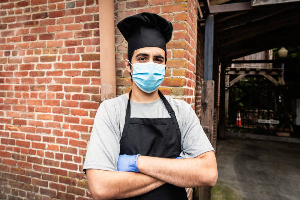 istock Young chef posing with a protective mask and gloves during a break looking at the camera 1224722469