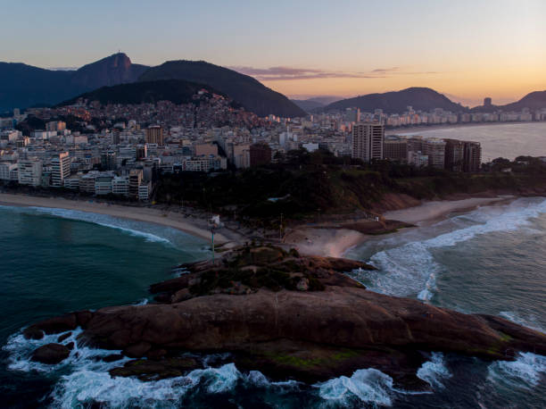 istock Swirling ocean wave pattern at Arpoador rock in Rio de Janeiro, Brazil, with Ipanema beach and wider cityscape in the background against a colourful sky at sunrise 1224726394