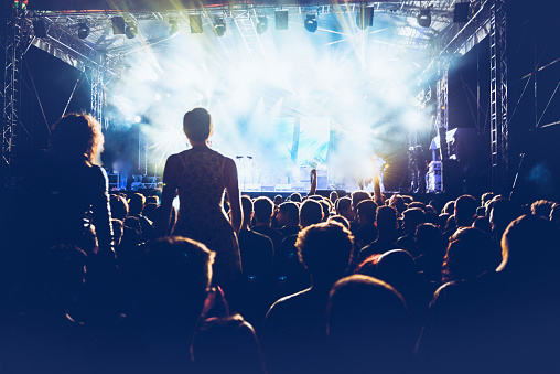 Cheering crowd in front of a stage at rock concert