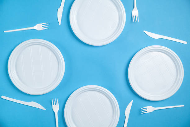 istock White plastic plates, forks and knifes on blue background. 1224734610