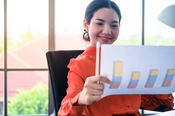 istock Business women with graph paper at office workplace. 1224735916