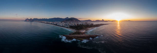 istock Swirling ocean wave pattern at Arpoador rock in Rio de Janeiro, Brazil, with Ipanema beach and wider cityscape in the background against a colourful sky at sunrise 1224736668