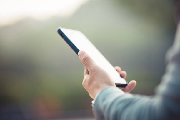 Asian woman using smartphone outdoors in the morning