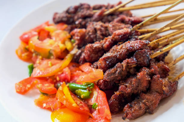 Lamb satay Close up shot of tasty lamb satay with chopped tomatoes and chili for eid al-adha dinner meal traditional malaysian food stock pictures, royalty-free photos & images