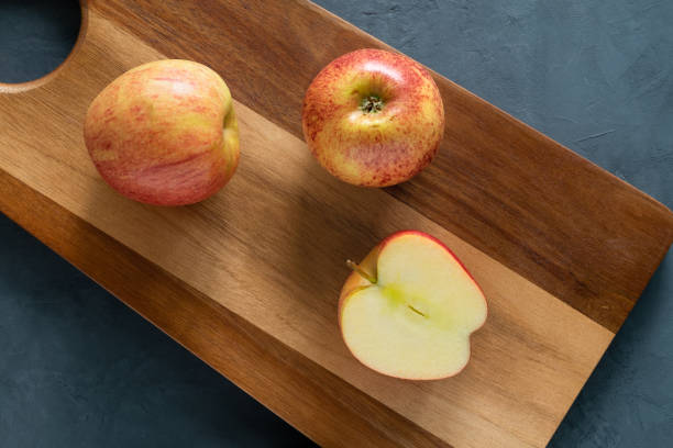 istock Two whole apples and one half lie on the cutting board. 1224739528