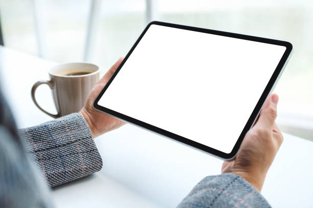 istock a woman holding black tablet pc with blank white screen with coffee cup on the table 1224740678