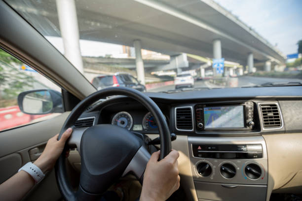 istock People hands holding steering wheel while driving car on city road 1224742108