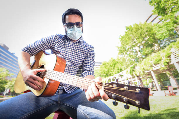 istock Life under Covid-19 - Musician with a mask plays guitar 1224743080