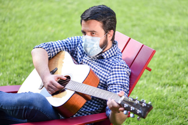 istock Life under Covid-19 - Musician with a mask plays guitar 1224744468