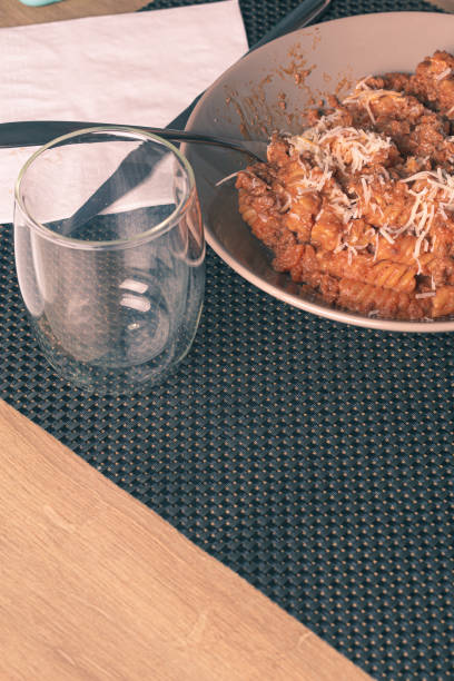 Fusilli italian pasta plate with bolognese sauce and grated cheese served on a white plate
