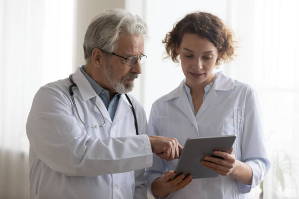 istock Medical team of two professional doctors talking using digital tablet 1224749380