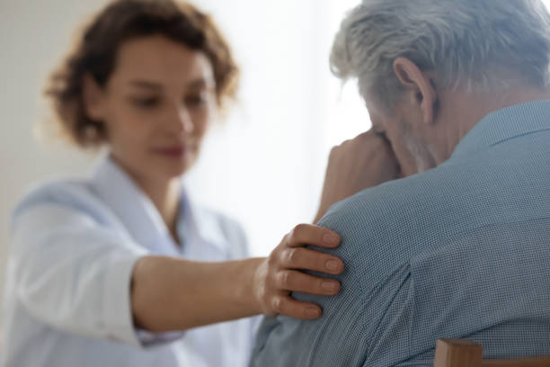 Female doctor touching shoulder comforting upset senior patient, closeup Female professional doctor touching shoulder comforting upset senior patient having geriatric disease expressing trust, support concept. Geriatrician helping lonely elderly crying man. Close up view old man depressed stock pictures, royalty-free photos & images