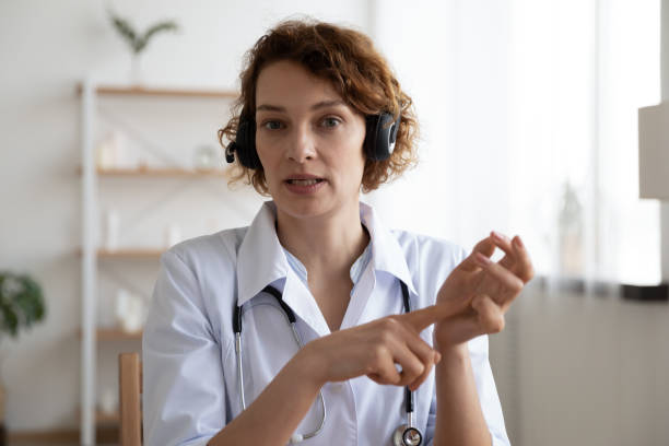 istock Female professional doctor wearing headset speaking looking at camera 1224749422