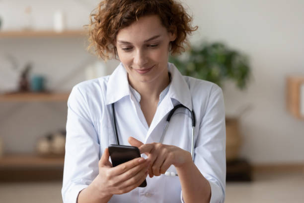 istock Young female physician using mobile app consulting remote patient online 1224749439
