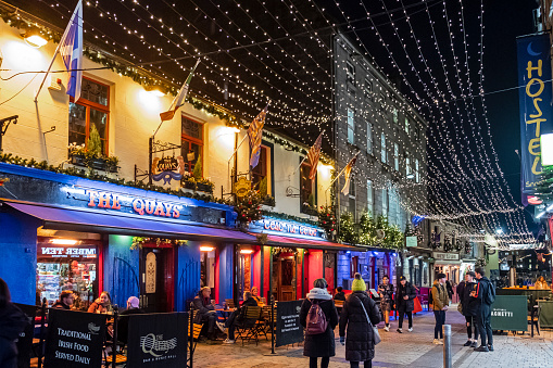 People strolling under Christmas decorations in downtown Galway, a city in the West of Ireland.