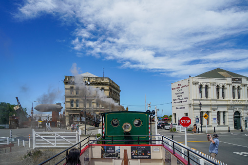 An old-fashioned sightseeing steam train just entered Harbourside station in historic town Oamaru, New Zealand.