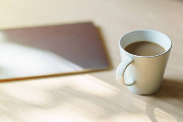 istock Work desk with a laptop computer, a cup of coffee, with morning sunlight. 1224758605