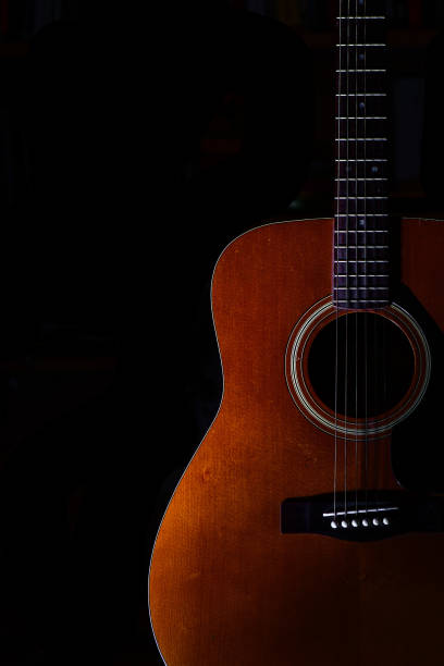 istock Acoustic guitar on a black background 1224758641