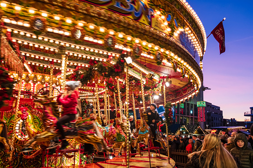 Children enjoy the ride on a carousel at the Christmas Market set up in Millennium Square in downtown Leeds.