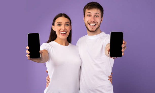 istock Happy couple showing blank cellphone screen to camera 1224768611