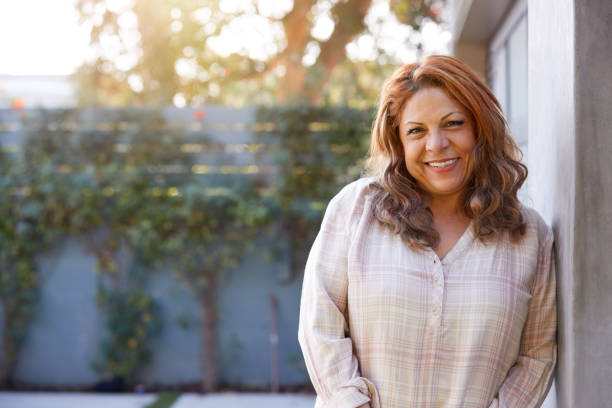 Portrait Of Smiling Senior Hispanic Woman In Garden At Home Against Flaring Sun Portrait Of Smiling Senior Hispanic Woman In Garden At Home Against Flaring Sun latin woman stock pictures, royalty-free photos & images