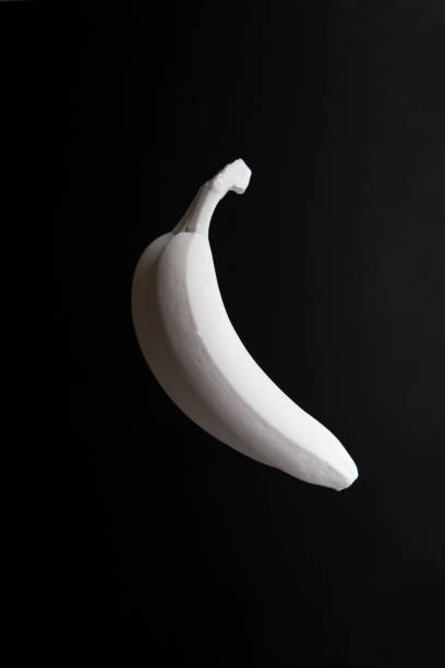 istock Banana in white paint on black background 1224769742
