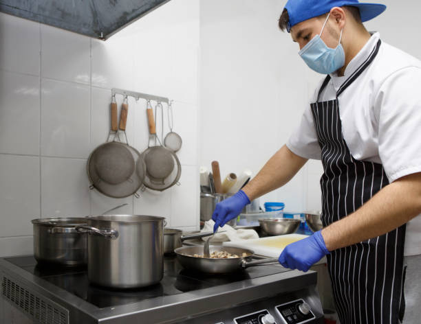 istock Man in protective mask and gloves cooking on kitchen 1224770020