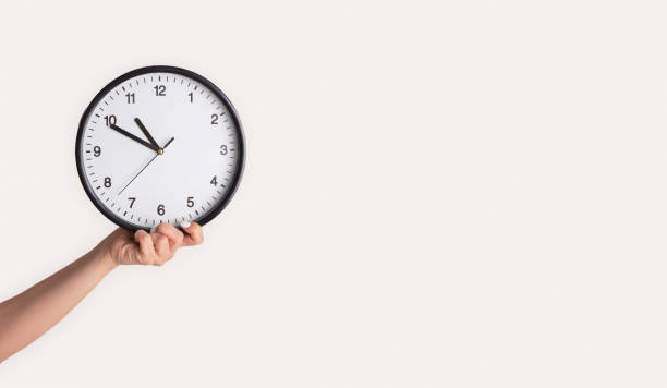 istock Effective time management. Female hand holding analog clock on light background, close up. Copy space. Panorama 1224771456