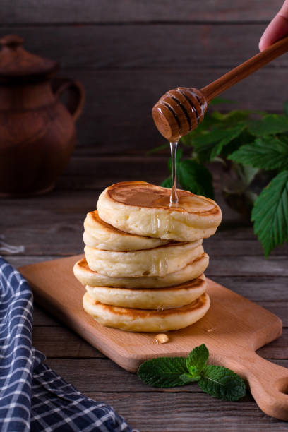 istock Stack of pancakes with honey syrup on wooden dark background 1224772454