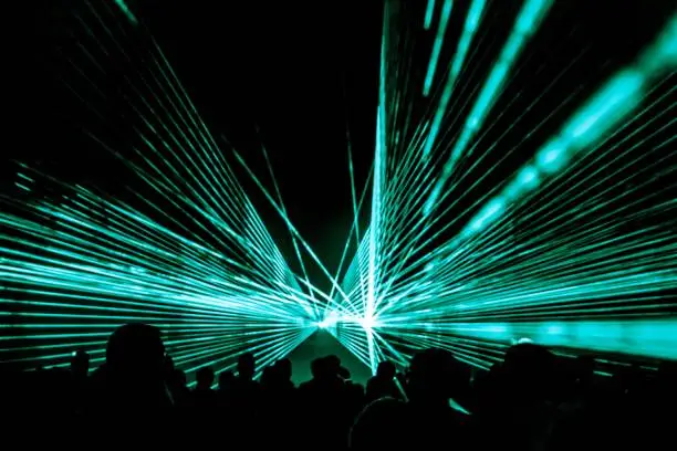Photo of Turquoise laser show nightlife club stage at party people crowd