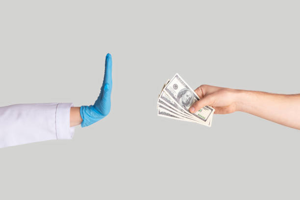 istock Unrecognizable female doctor refusing bribe from patient on light background, closeup of hands 1224772648