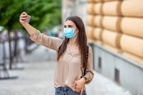 istock Woman in Face Mask Taking Selfies. 1224772929